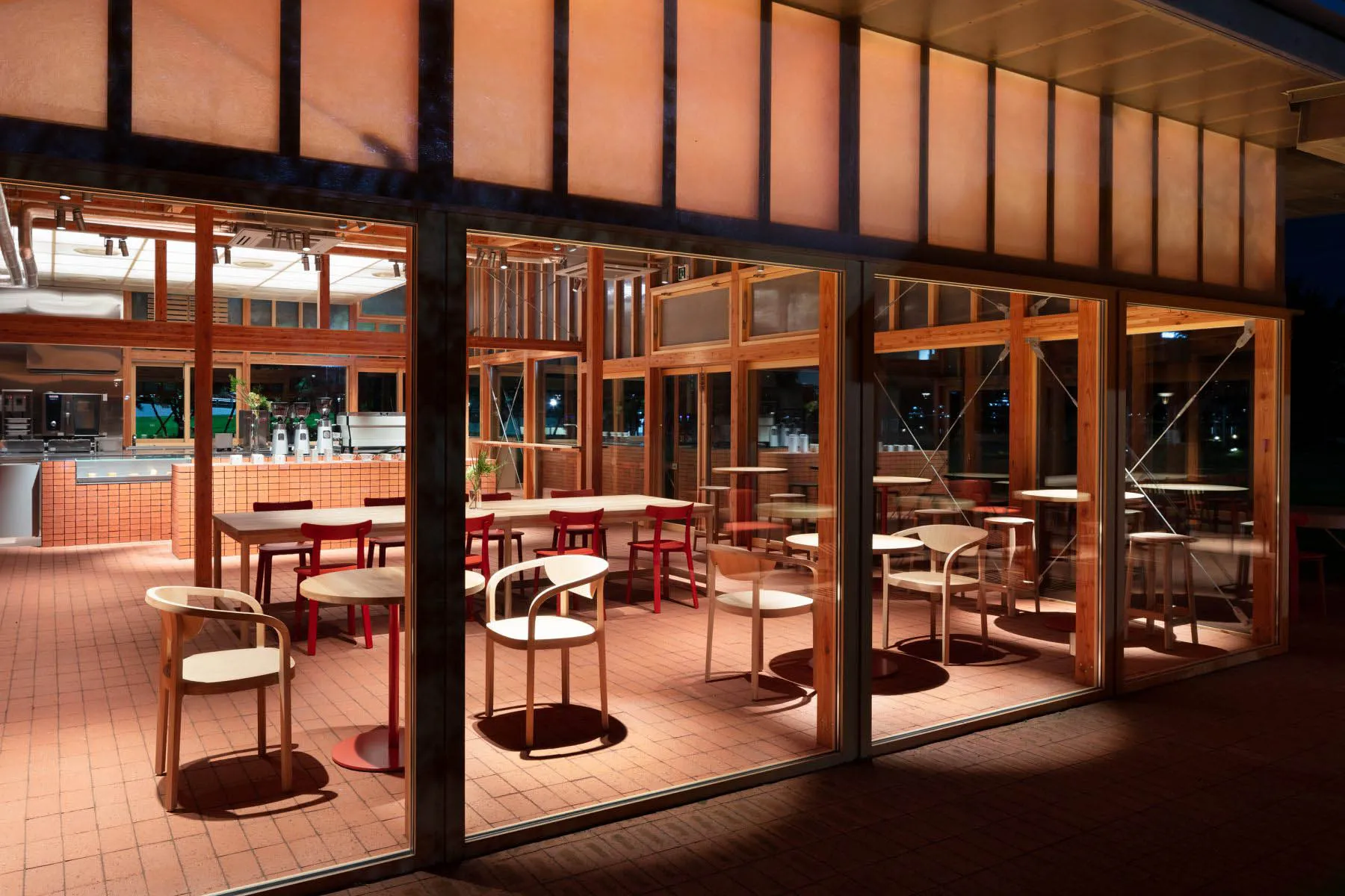 現代餐廳室內,木質餐桌椅、玻璃牆與裸露橫樑