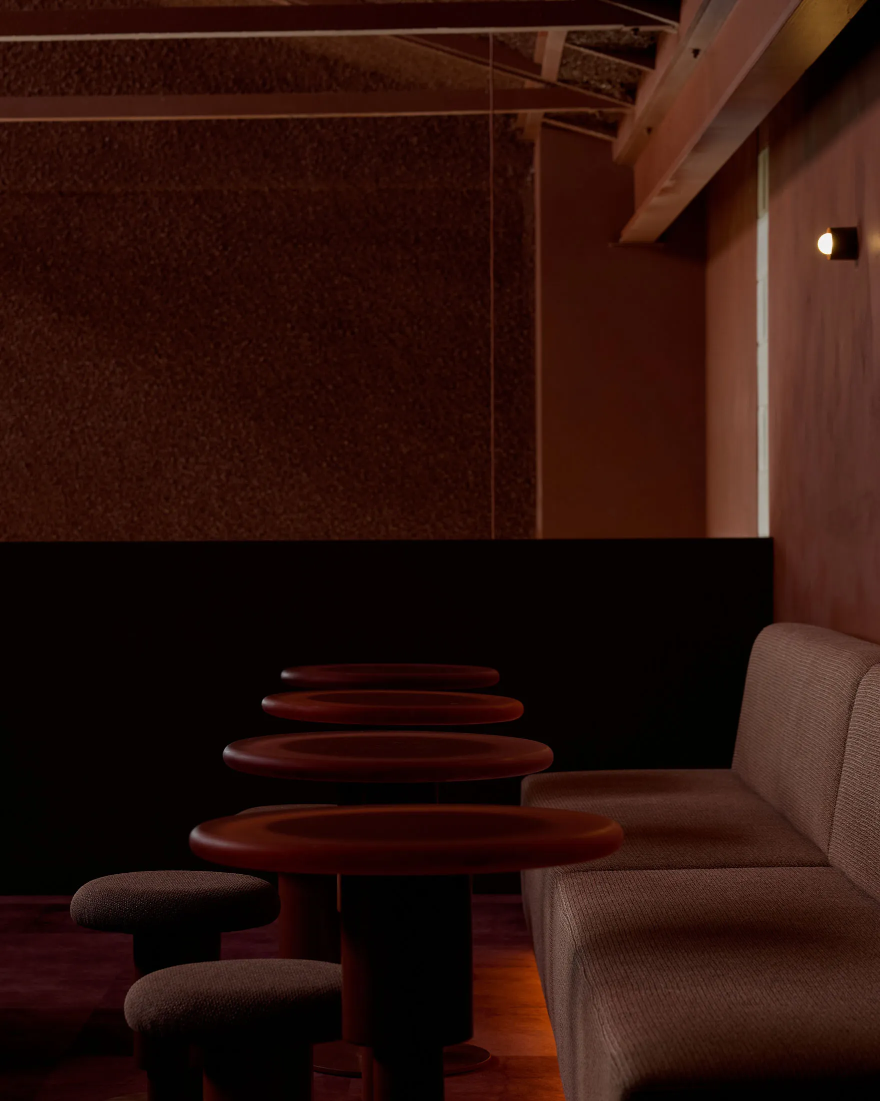 Contemporary coffee shop interior featuring red lighting and fabric seating.