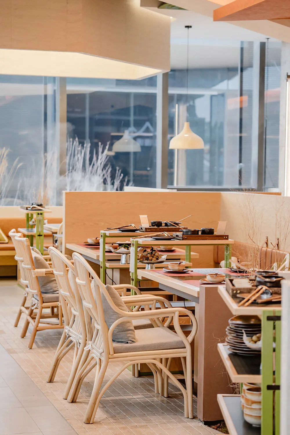 A modern restaurant interior designed with a combination of wooden and glass materials, featuring clean lines and natural lig