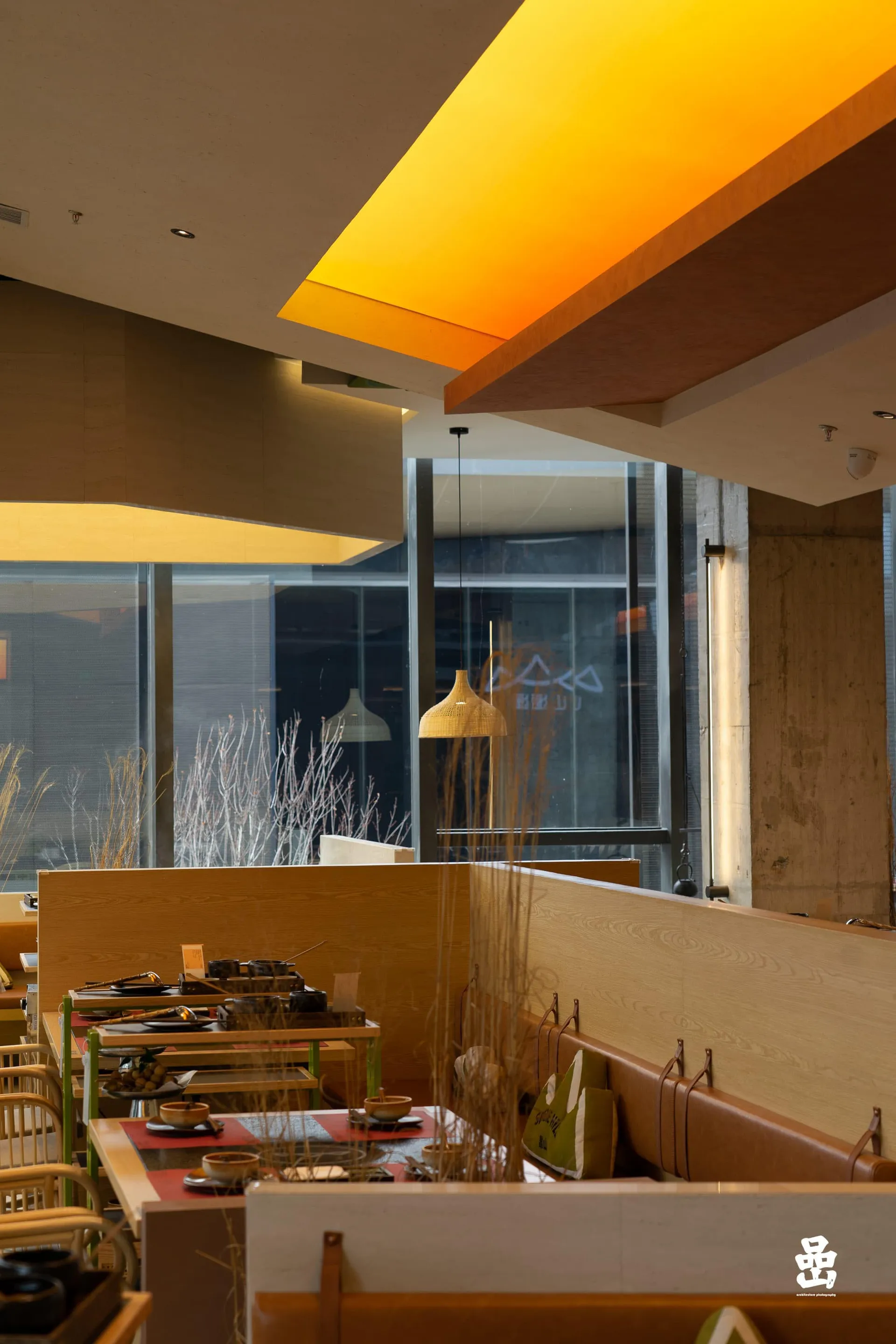 A modern restaurant interior featuring warm lighting and wooden elements.