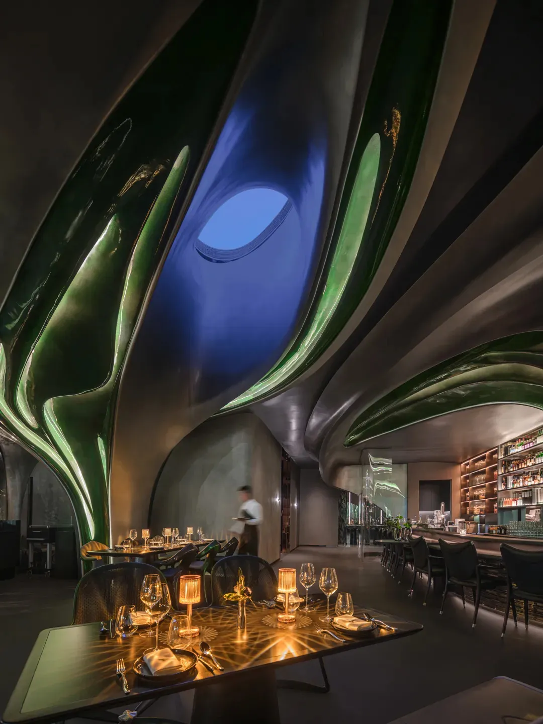 Luxurious modern restaurant interior with metallic ceiling and lighting features.