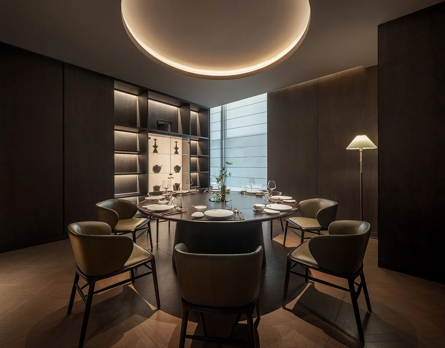 Minimalist dining room with wooden furniture and a round dining table.