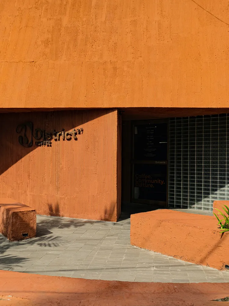 咖啡店的磚牆與混凝土外觀,牆面展示「Distrikt Coffee」字樣。