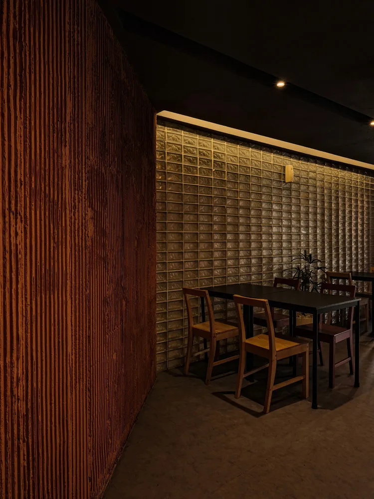 Modern restaurant interior featuring glass brick walls and wooden chairs