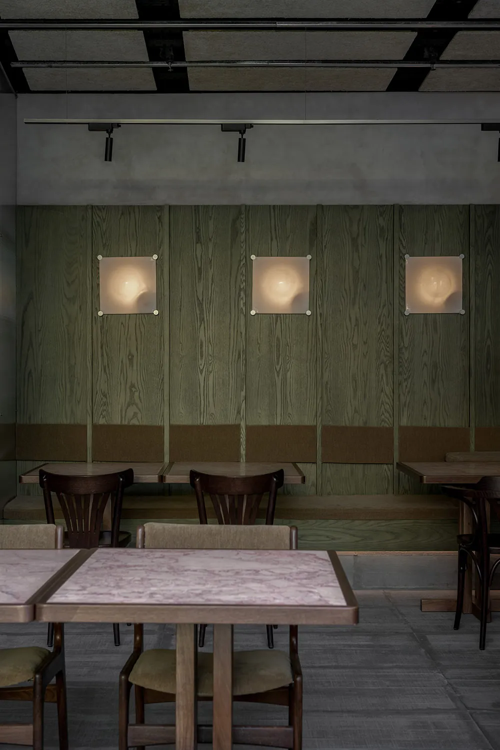 Modern industrial-style restaurant interior with wooden paneling and seating.