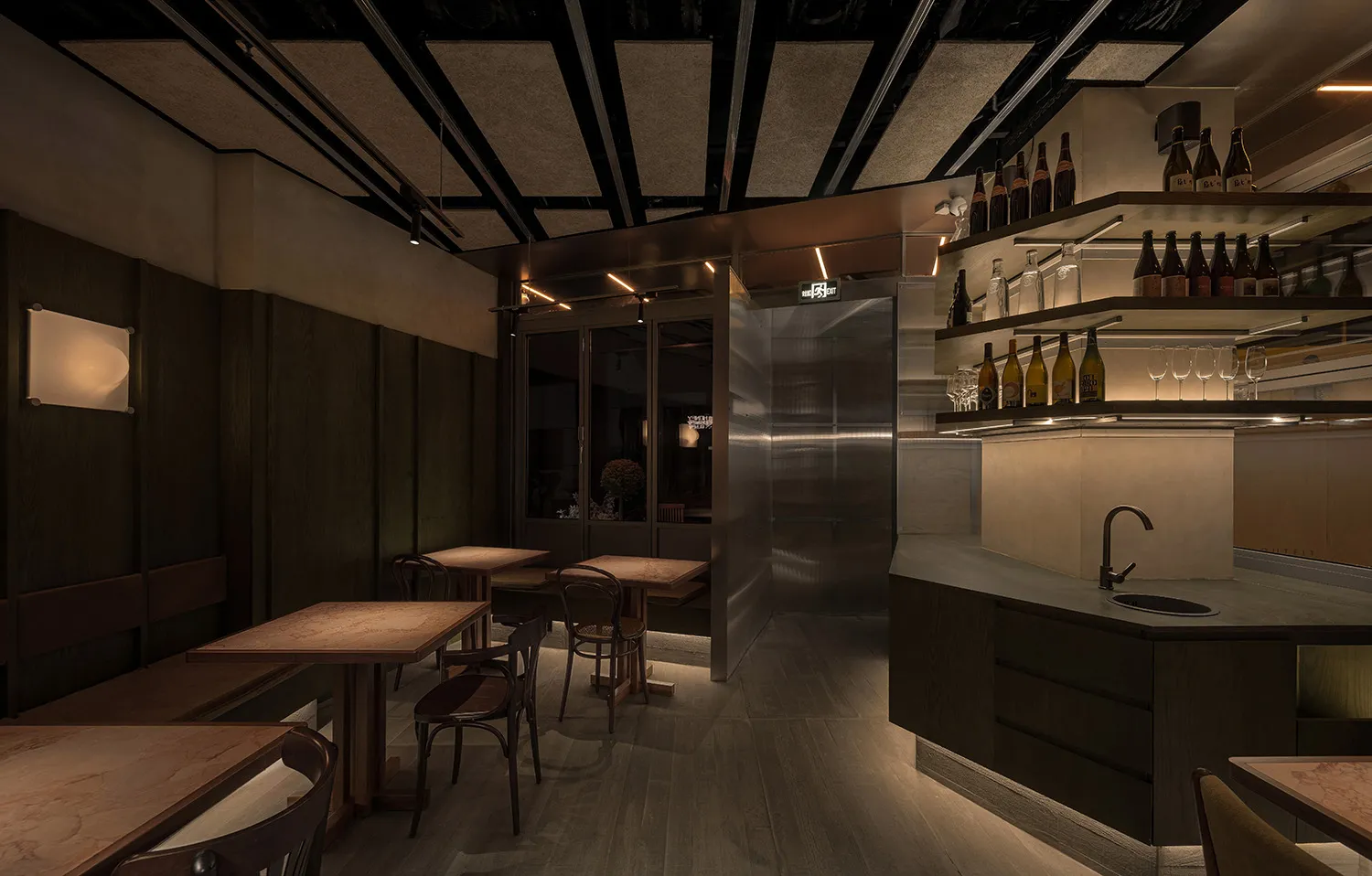 Modern industrial-style bar with metallic shelving, wooden furniture, and dark, minimalist design.