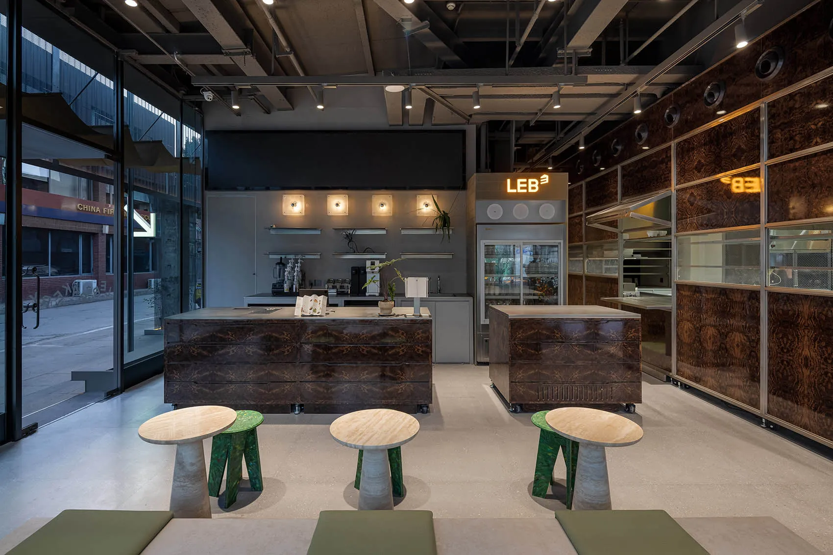 Interior view of a dark industrial-style coffee shop with modern seating and counter.