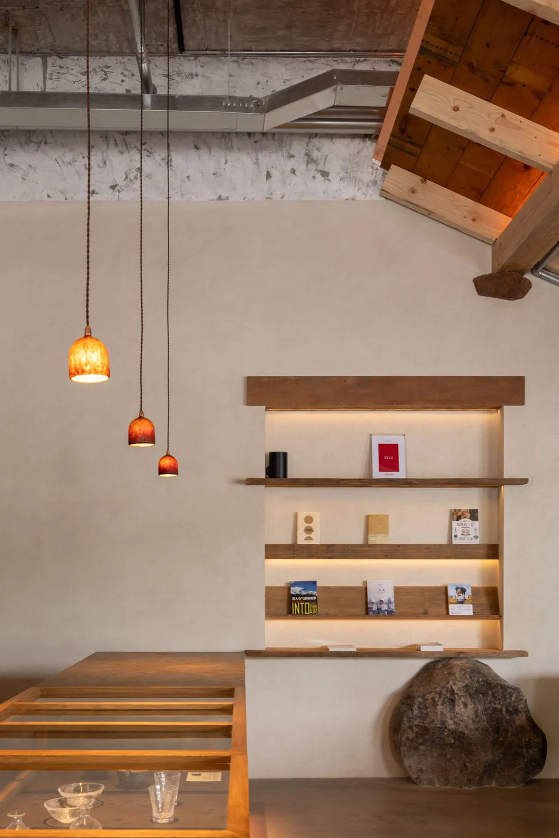 A retail store with a concrete floor, glass walls, and wooden shelves.
