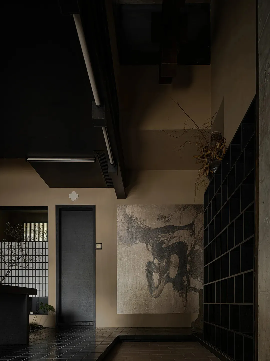 A modern industrial-style concrete lobby with dark wood flooring and minimalist design elements.