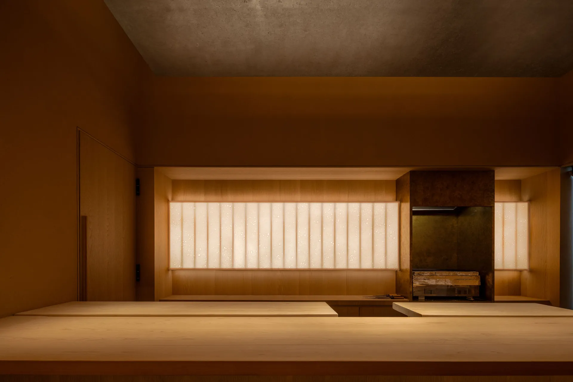 A modern restaurant interior with wooden tables and warm lighting.