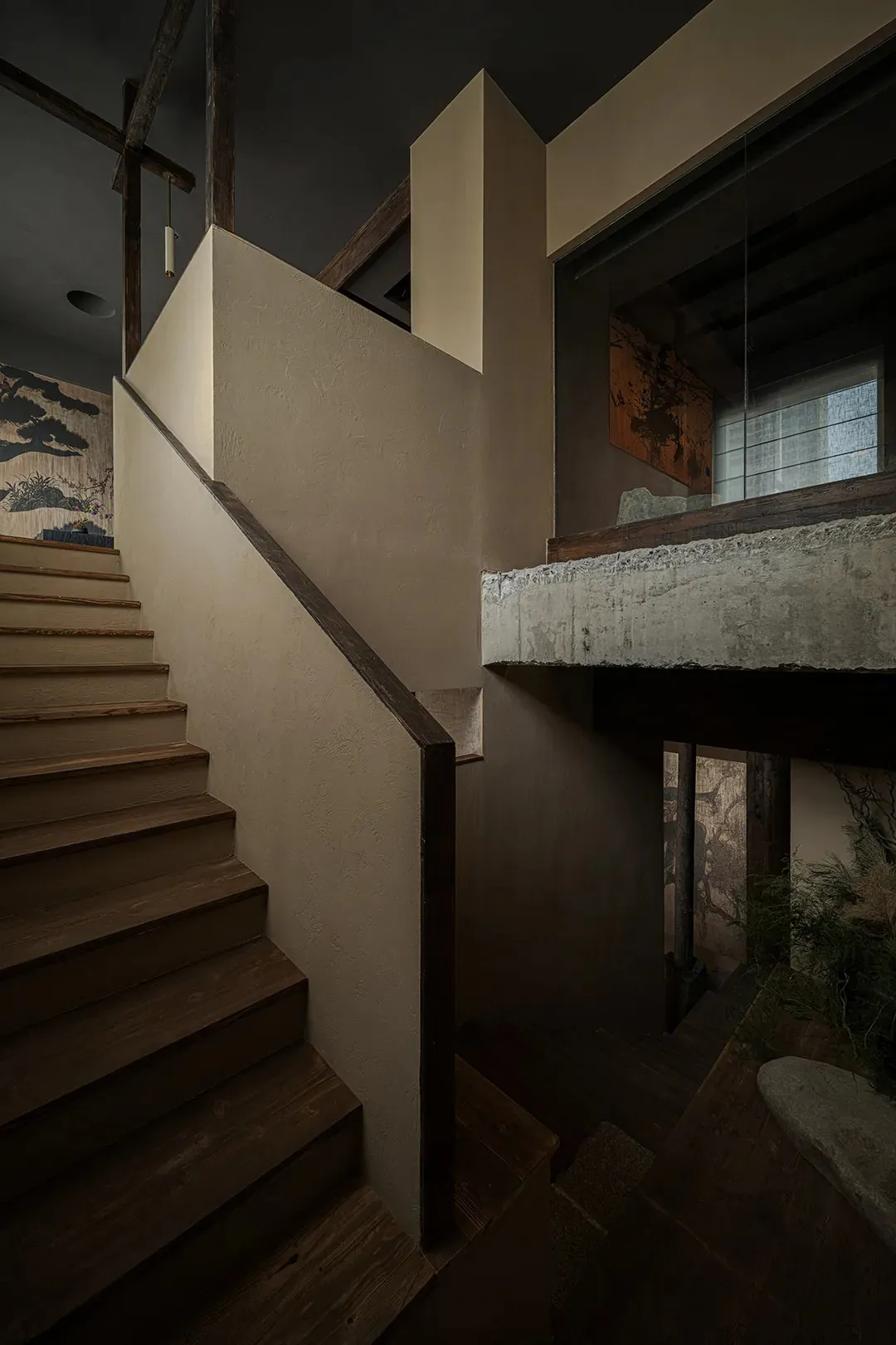 Modern interior with concrete staircase and wooden steps and handrail.