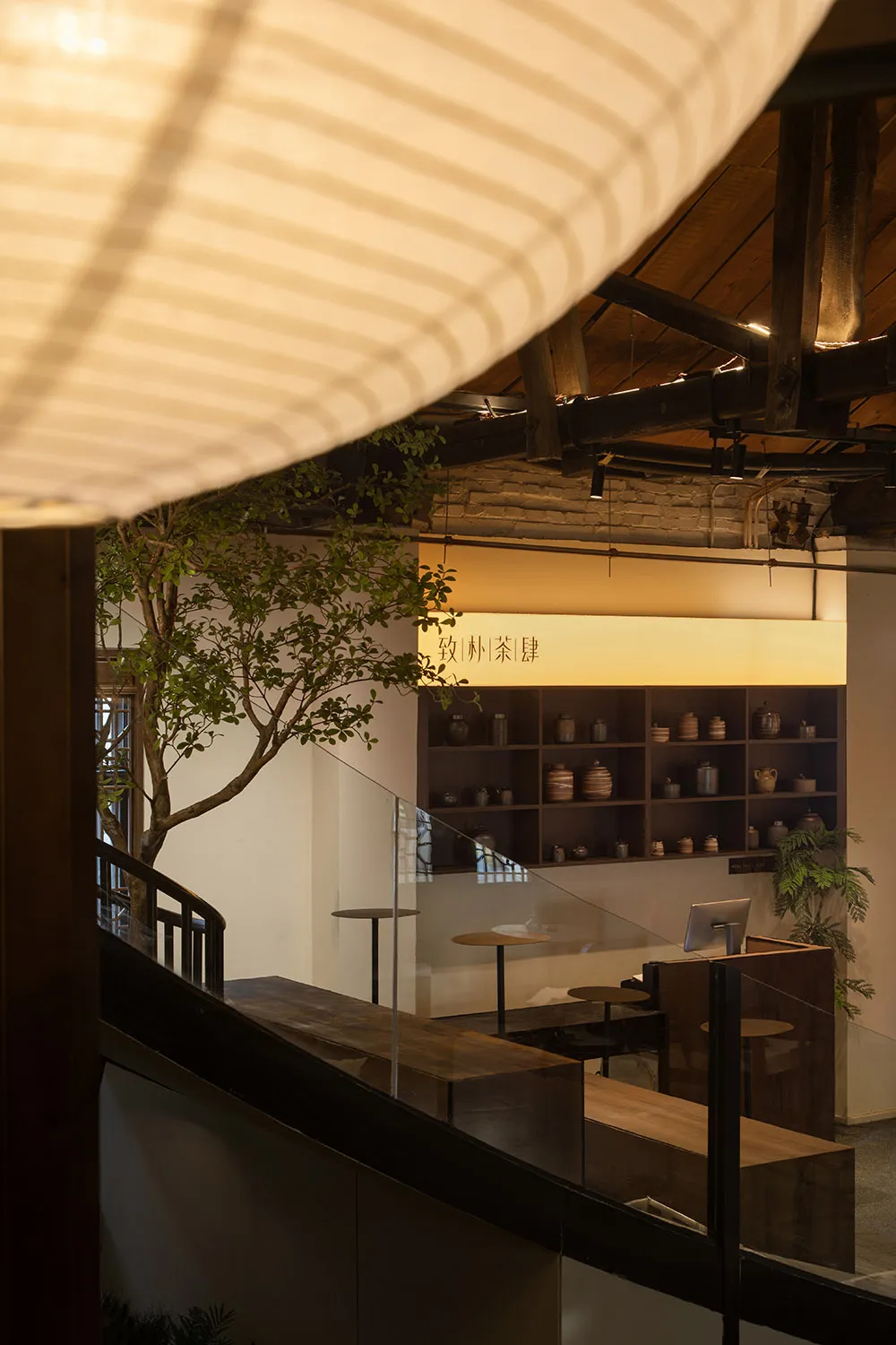 A view of an industrial-style coffee shop with exposed brick walls and concrete finishes.
