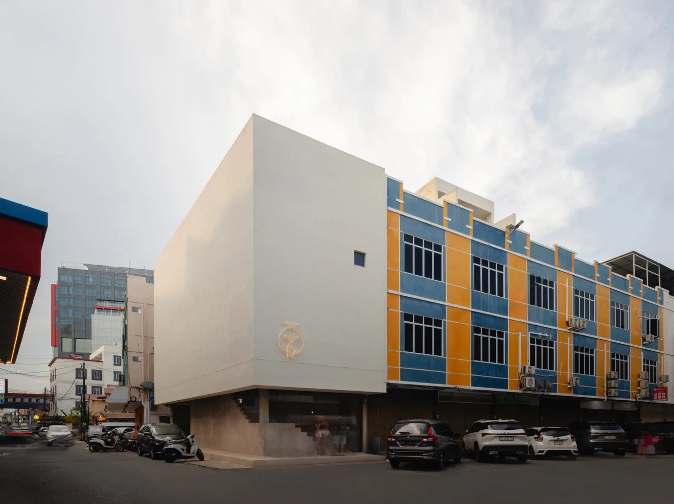 A modern building with a white exterior and blue and orange accents.