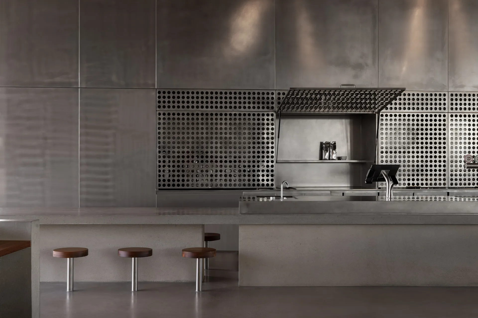 Modern kitchen bar featuring metallic and concrete materials with industrial design elements