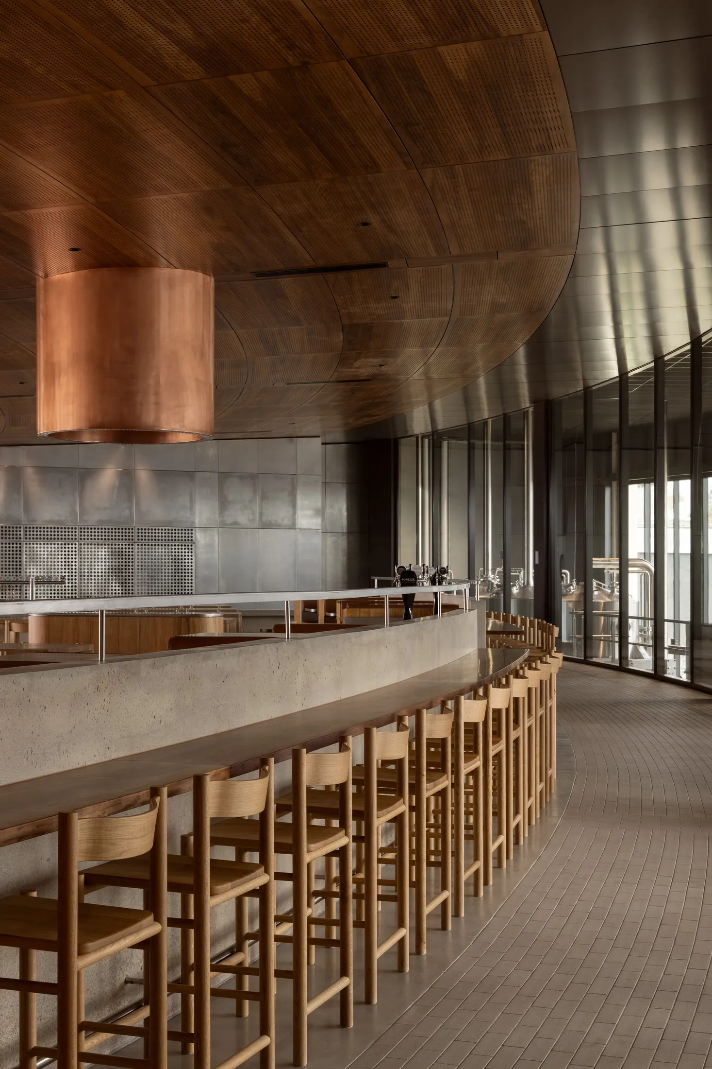 A minimalist restaurant interior featuring concrete, wood, and metal materials.