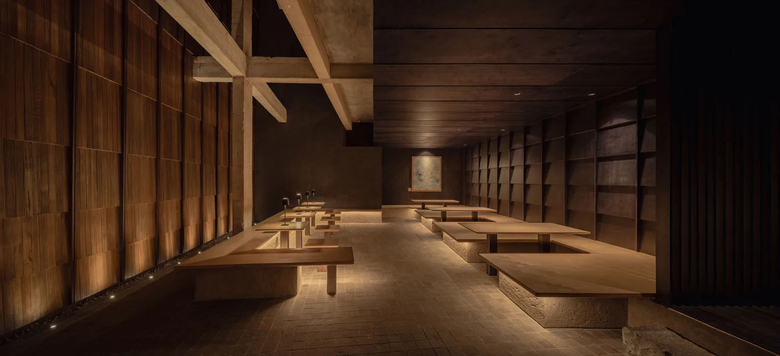 A spacious industrial-style restaurant with wooden tables and seating.