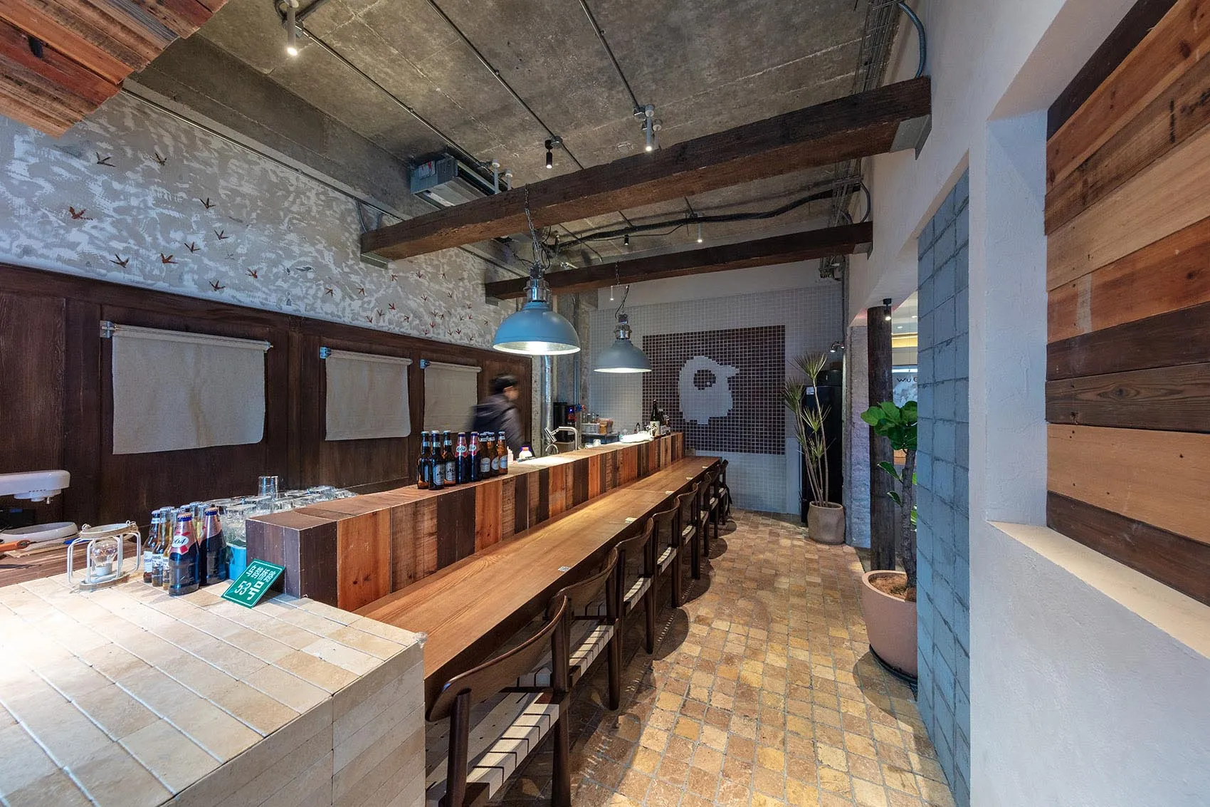 工業風餐廳,搭配木製座椅以及混凝土與磚牆。