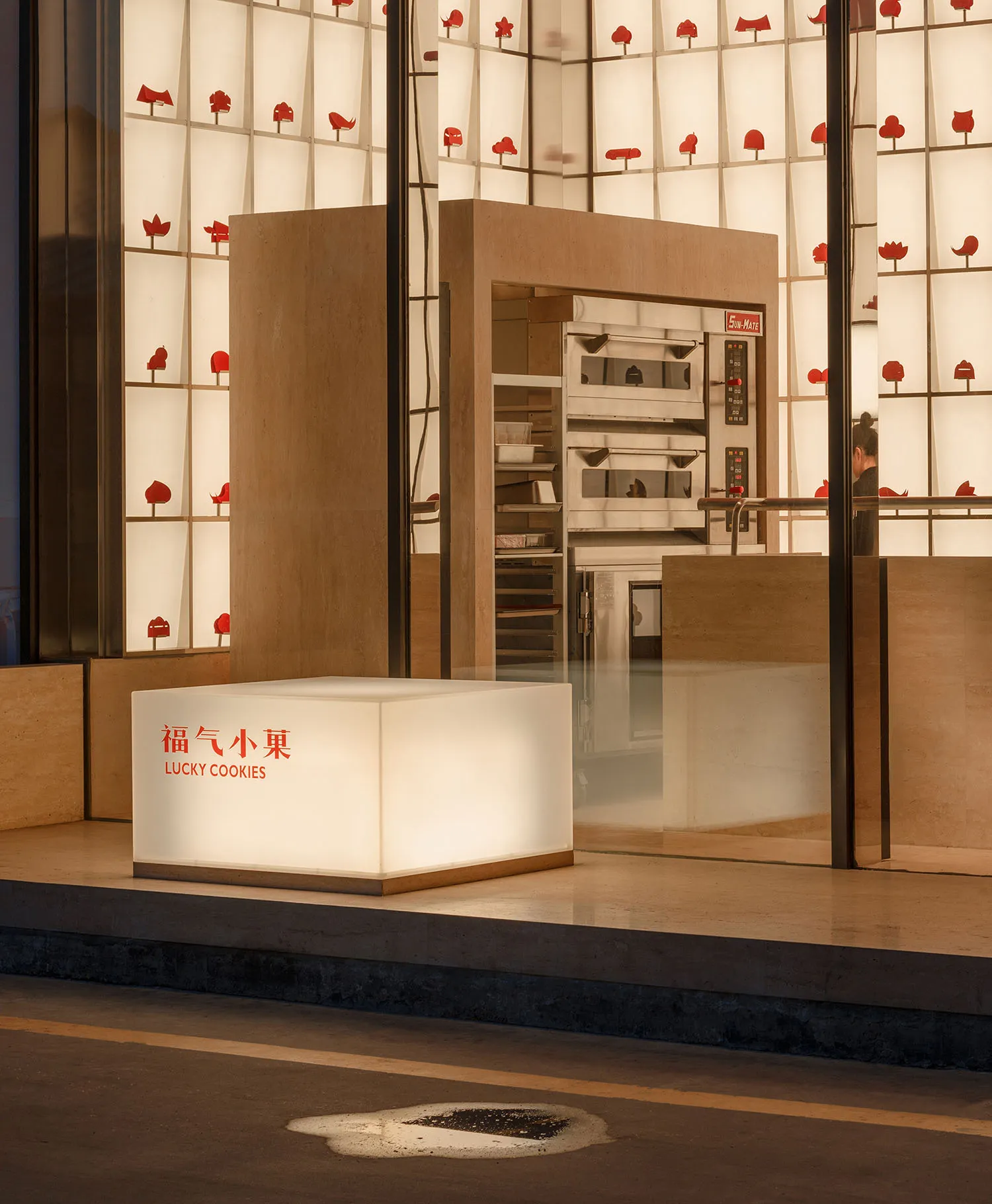 A modern retail storefront with a glass exterior and a cube-shaped illuminated sign