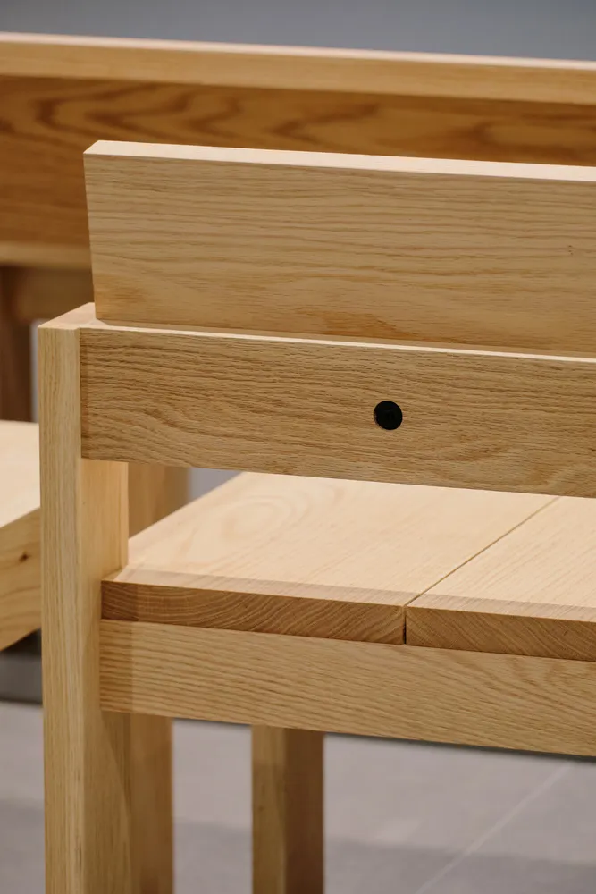 A modern minimalist wooden chair with a sleek, simple design.