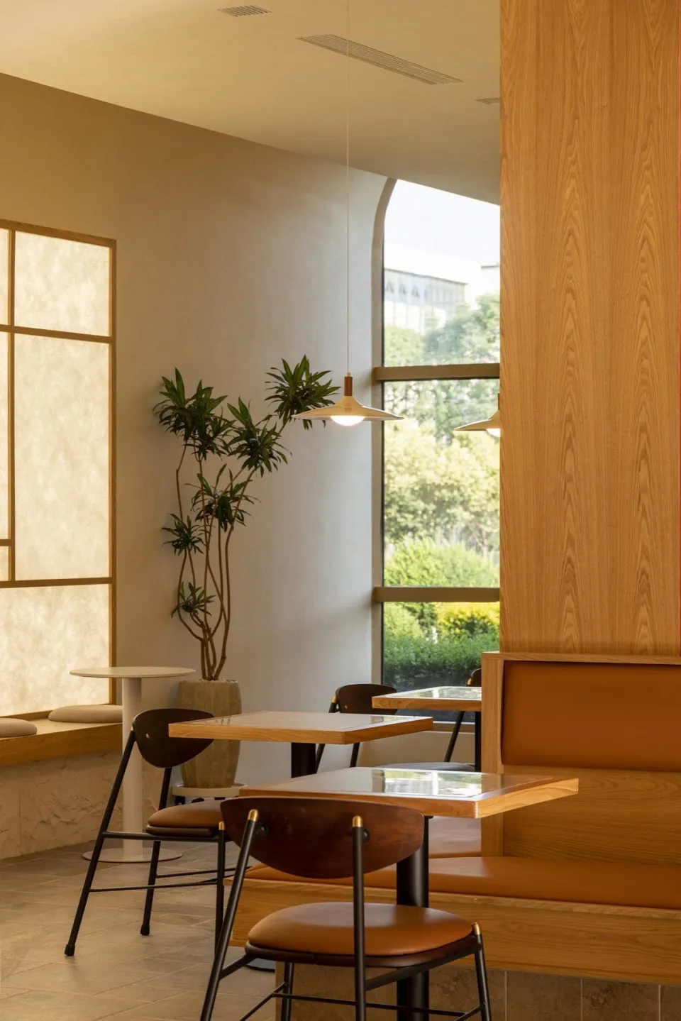 Modern cafe interior with wooden furniture and green plants