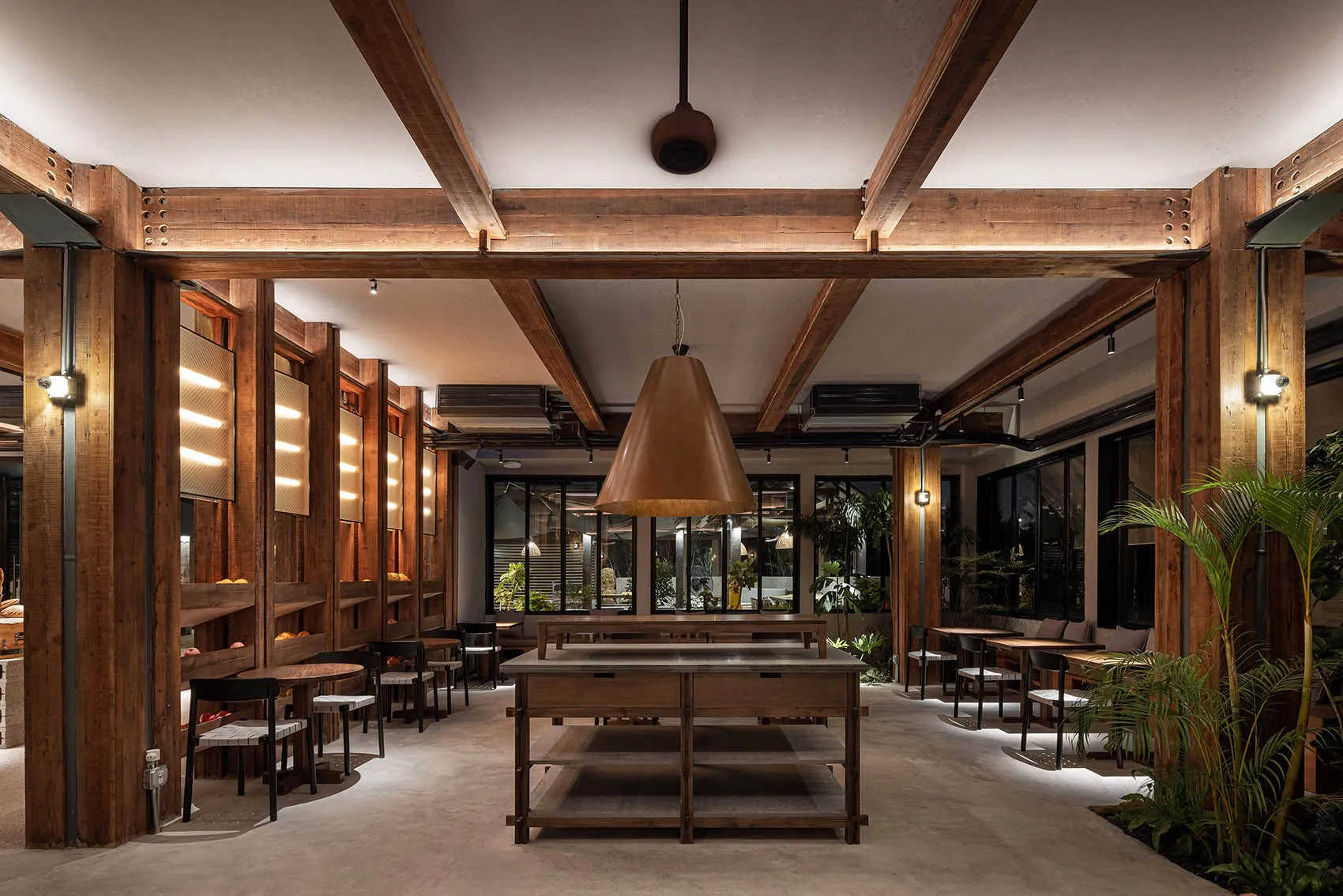A warm and inviting cafeteria interior with wooden walls and fixtures, featuring a central table and seating arrangements.