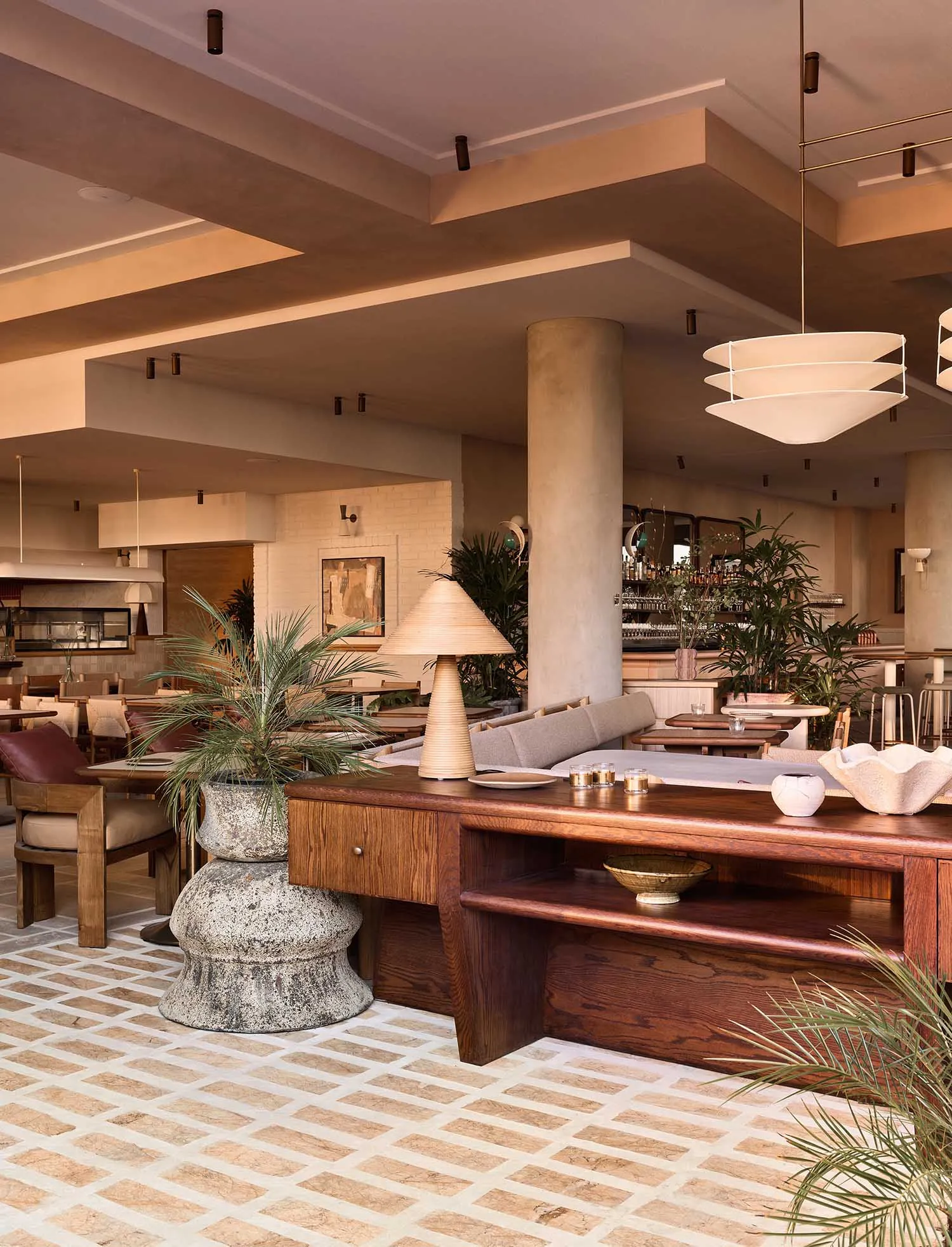 A spacious Mediterranean restaurant with wood furnishings, concrete accents, and cement flooring.