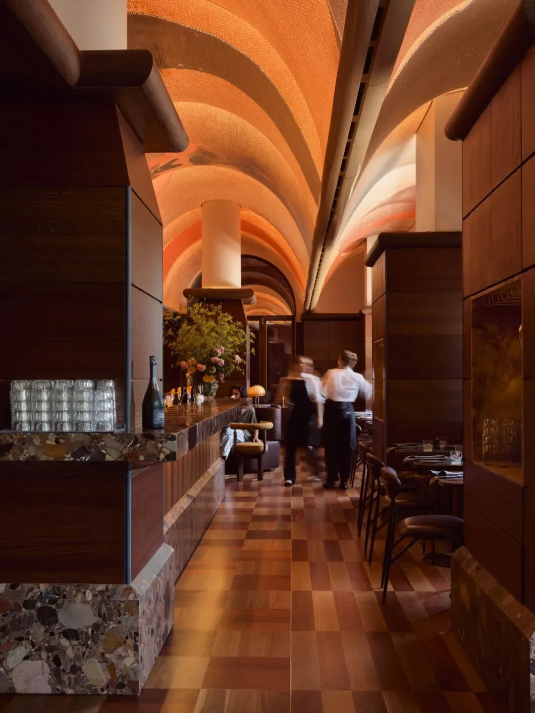 Industrial-themed restaurant bar interior with wood laminate flooring and a high ceiling arches