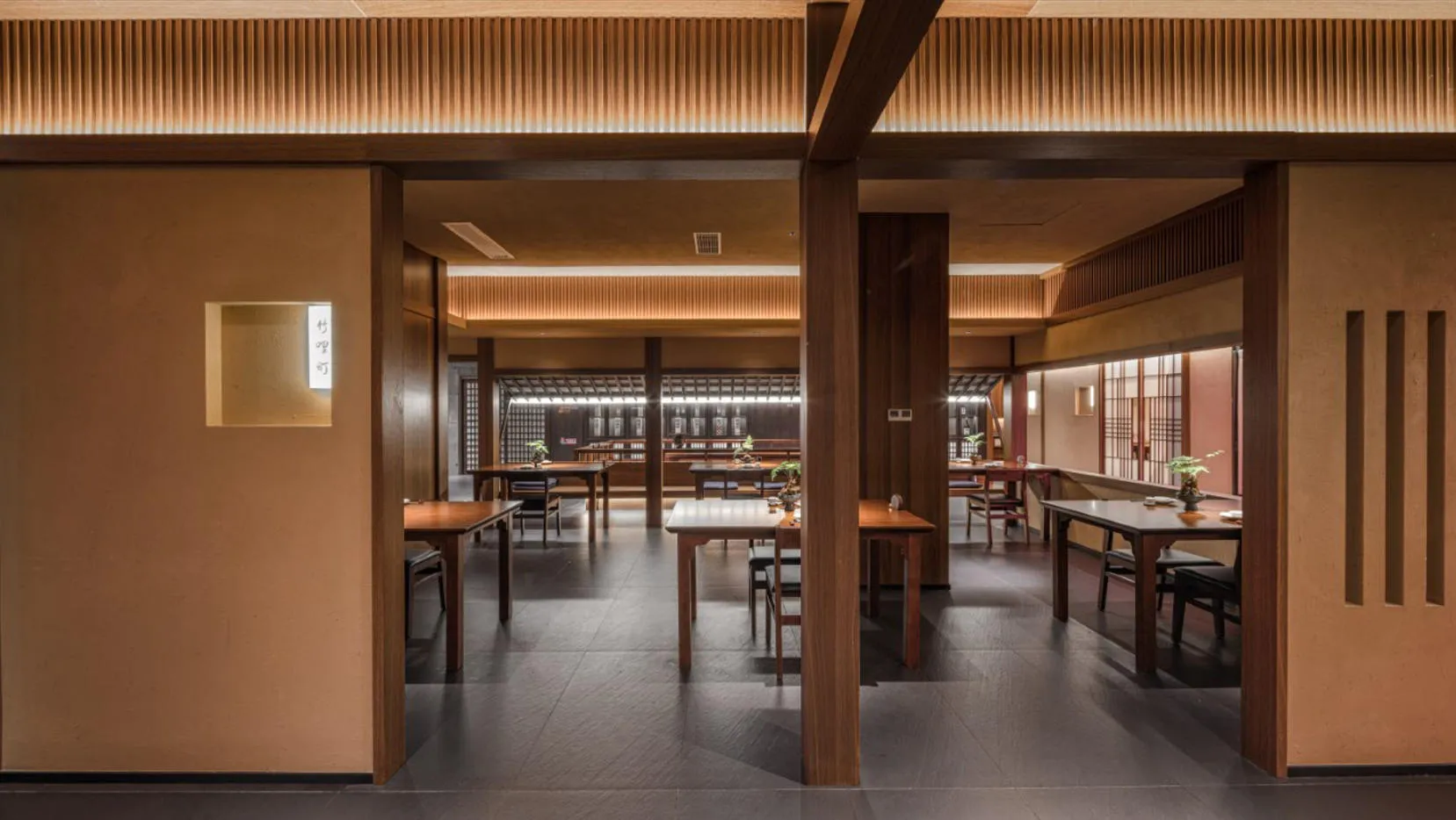 Modern restaurant interior with wooden tables, rustic wooden walls, and warm lighting.