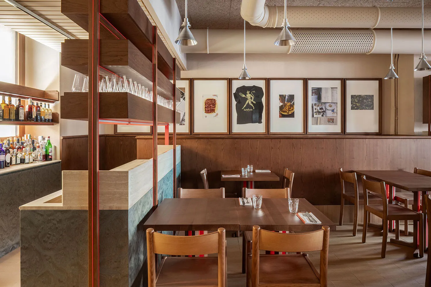 A cozy, industrial-themed restaurant interior with wooden tables, chairs, and shelves.