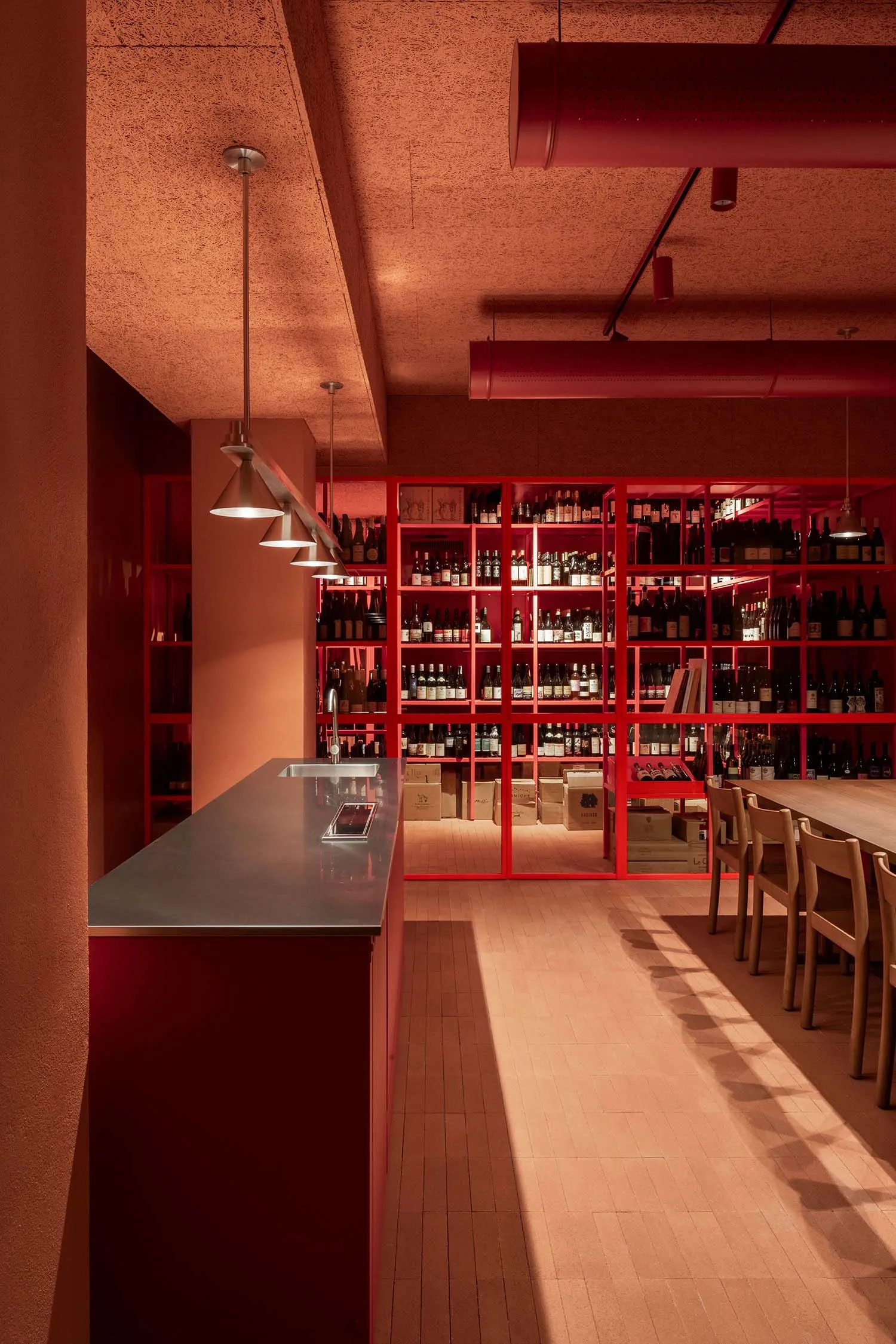 A modern wine bar with red materials and metal accents.