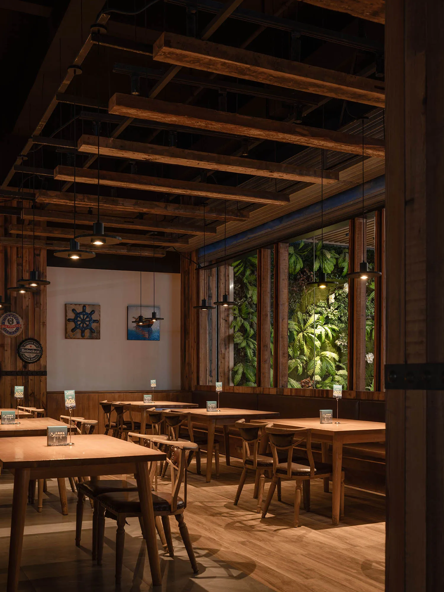 Industrial-themed restaurant with wooden furniture and green plants.