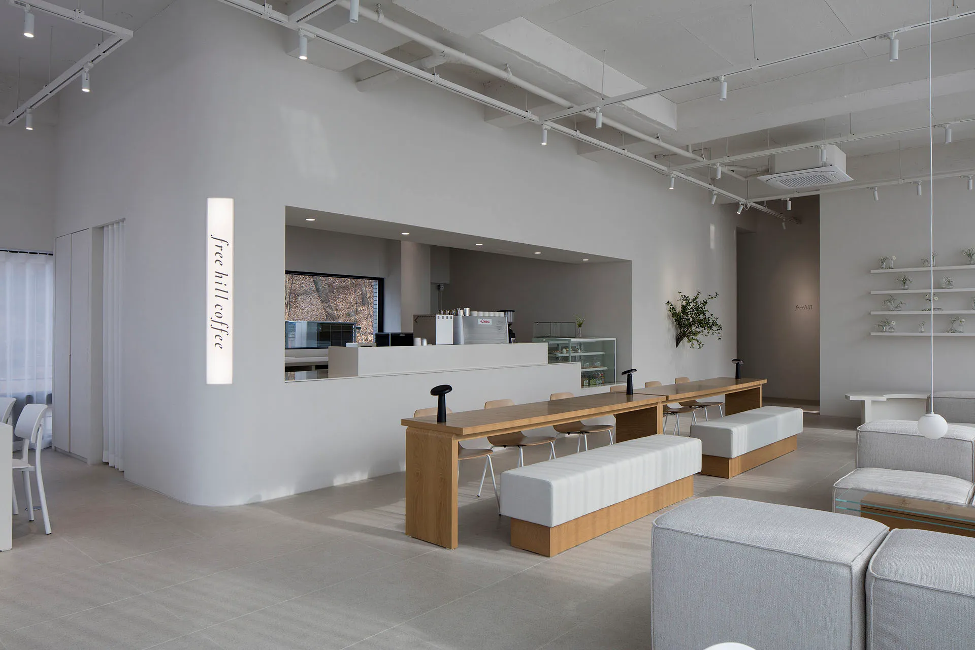 A minimalist coffee shop featuring wooden and concrete materials.
