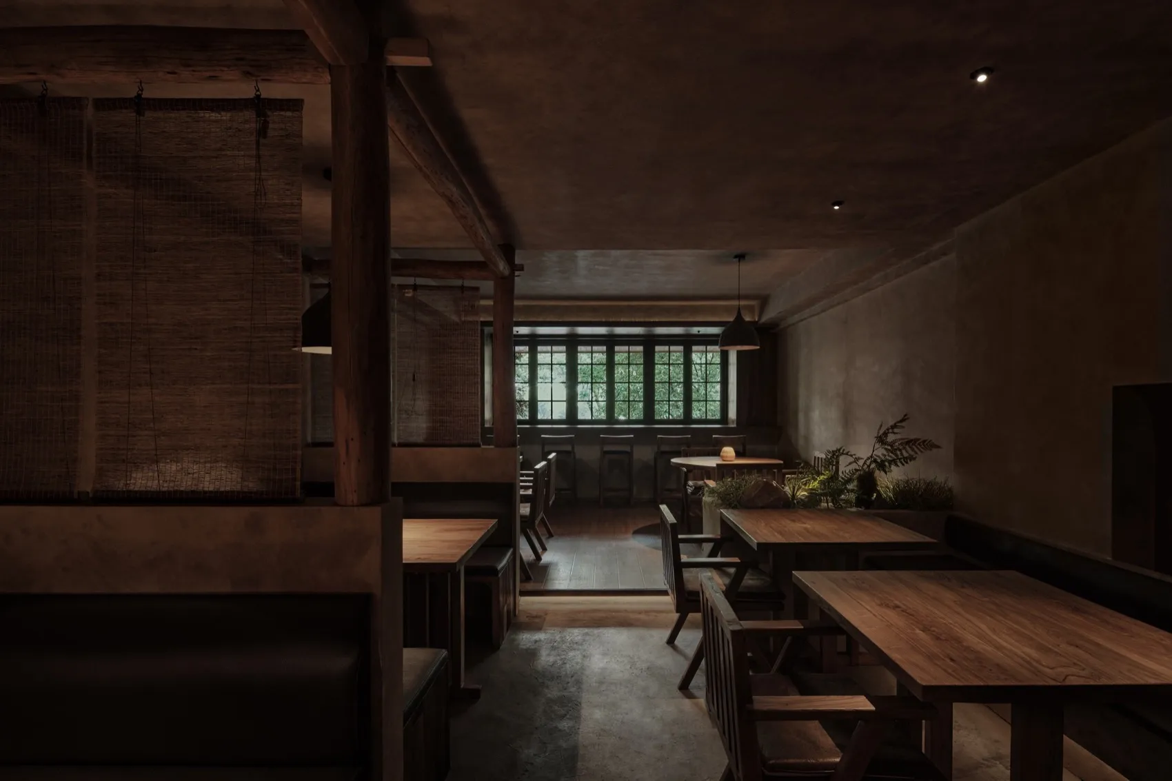 Interior of a restaurant featuring wooden tables, concrete flooring, and metallic accents.