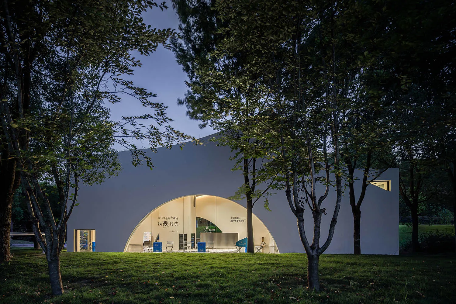 A minimalist modern pavilion constructed with glass and metal materials.