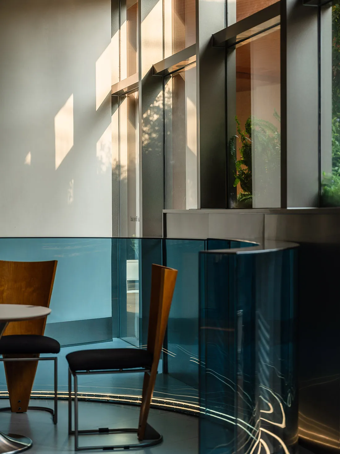 Interior of a modern cafe with glass walls and modern furniture.