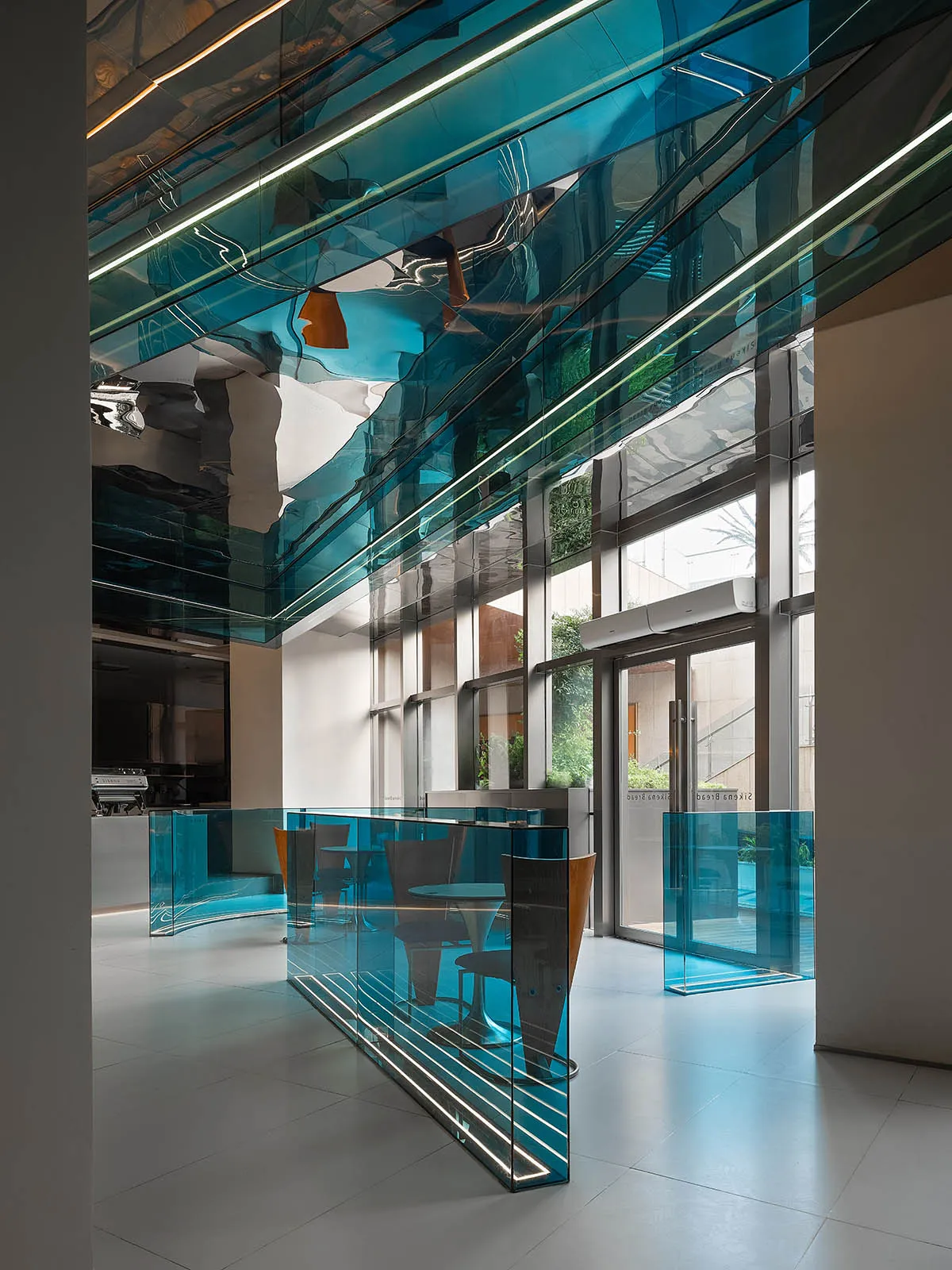 A modern cafe interior featuring glass walls and concrete flooring.