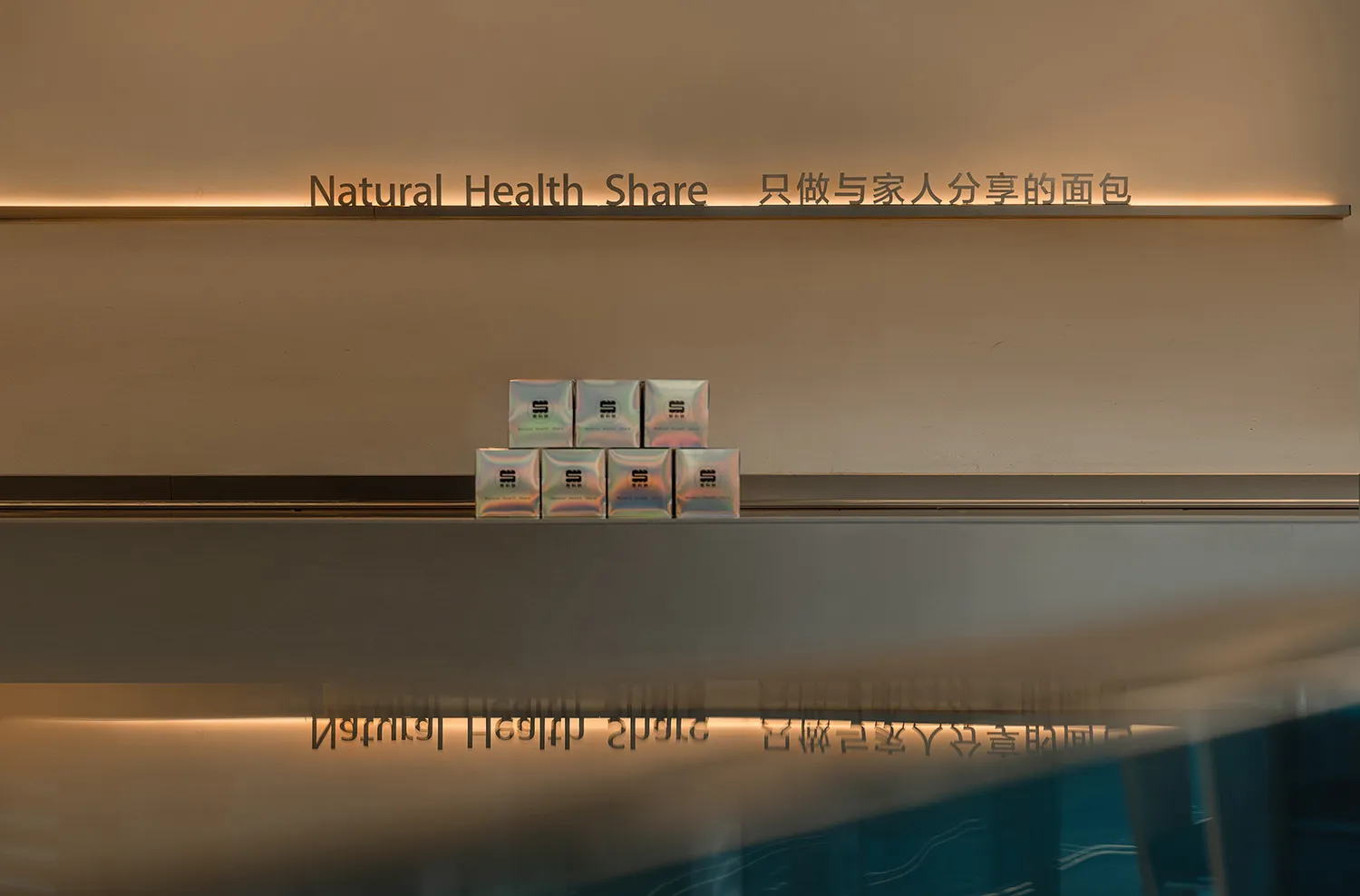 A modern retail interior featuring a glass wall displaying glass panels with text and design elements.