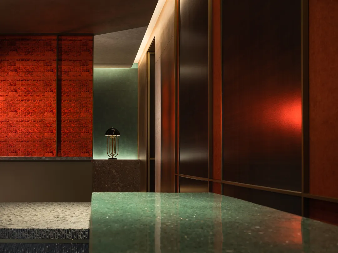 Modern entrance lobby featuring metallic textured walls and ceiling with green accents.