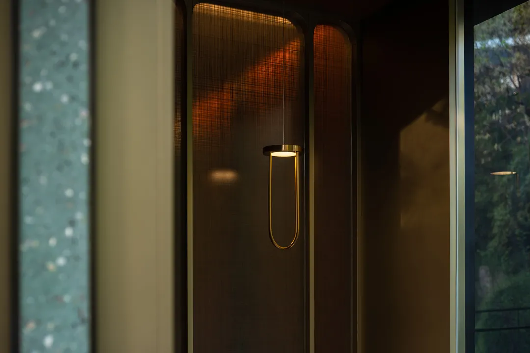Modern interior design featuring a brass pendant light hanging from a ceiling.