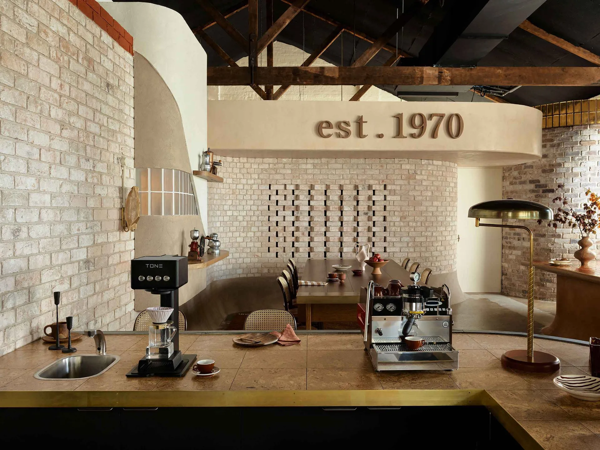 Industrial-style coffee shop featuring brick walls, metal accents, and wood furniture.