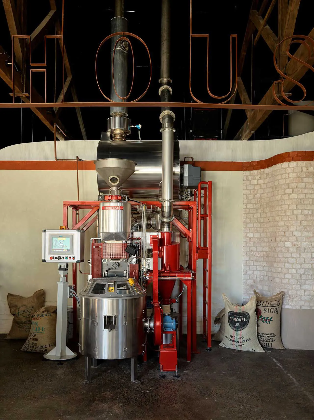 A large industrial coffee roasting machine with steel and brick materials.