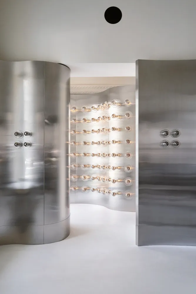Minimalist interior with metallic aluminum walls and light bulbs on the wall