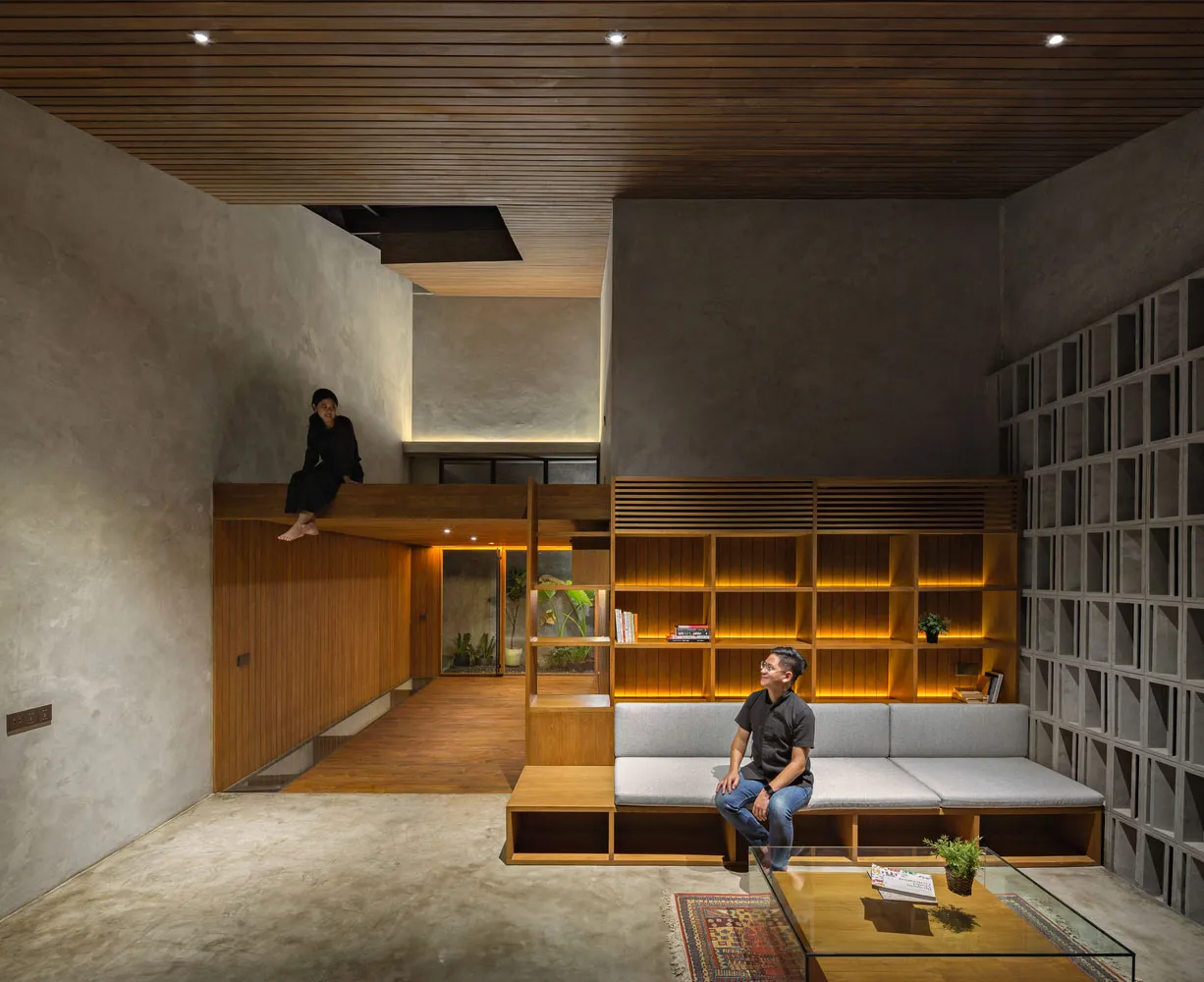 A modern living room with wooden shelves, a concrete floor, and a concrete wall.