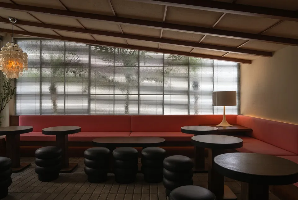 現代餐廳室內,配有布料座椅、木質餐桌、金屬高腳椅以及植栽。