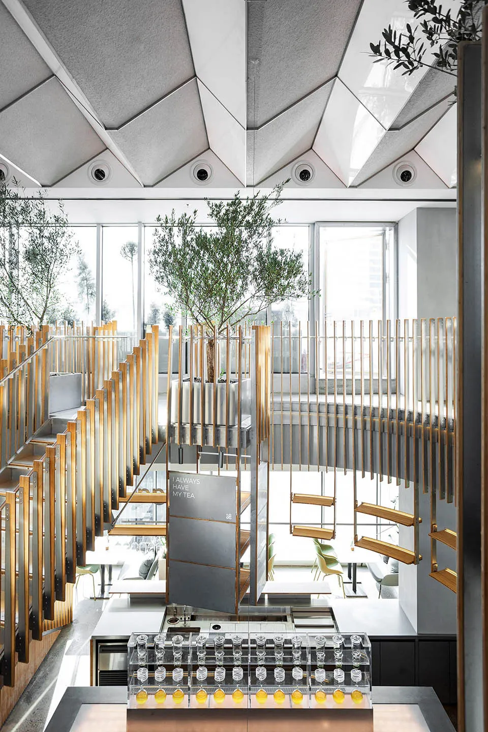 Modern-themed coffee shop interior with wood accents, metal railings, and glass partitions.