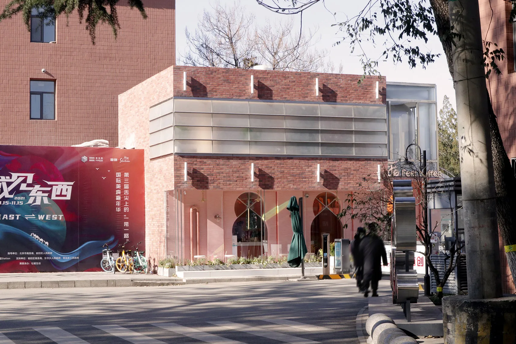 Modern storefront with brick facade, glass windows, and green awning.
