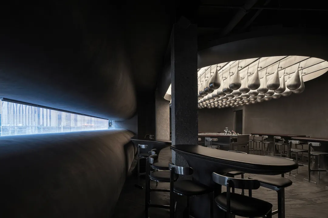 工業風餐廳室內,搭配金屬吧台椅以及混凝土牆面與地板