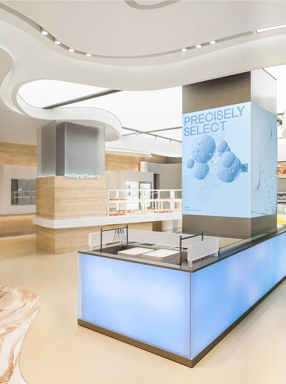A sleek, modern bakery counter featuring illuminated lighting and light-colored materials.