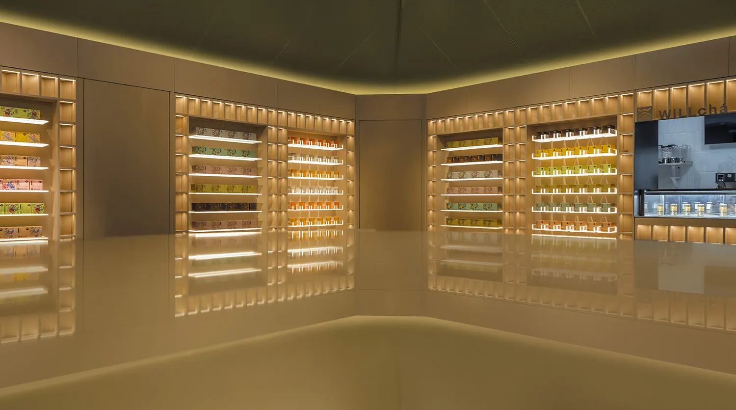A modern retail shop with illuminated shelves showcasing various products in a bright yellow lighting environment.
