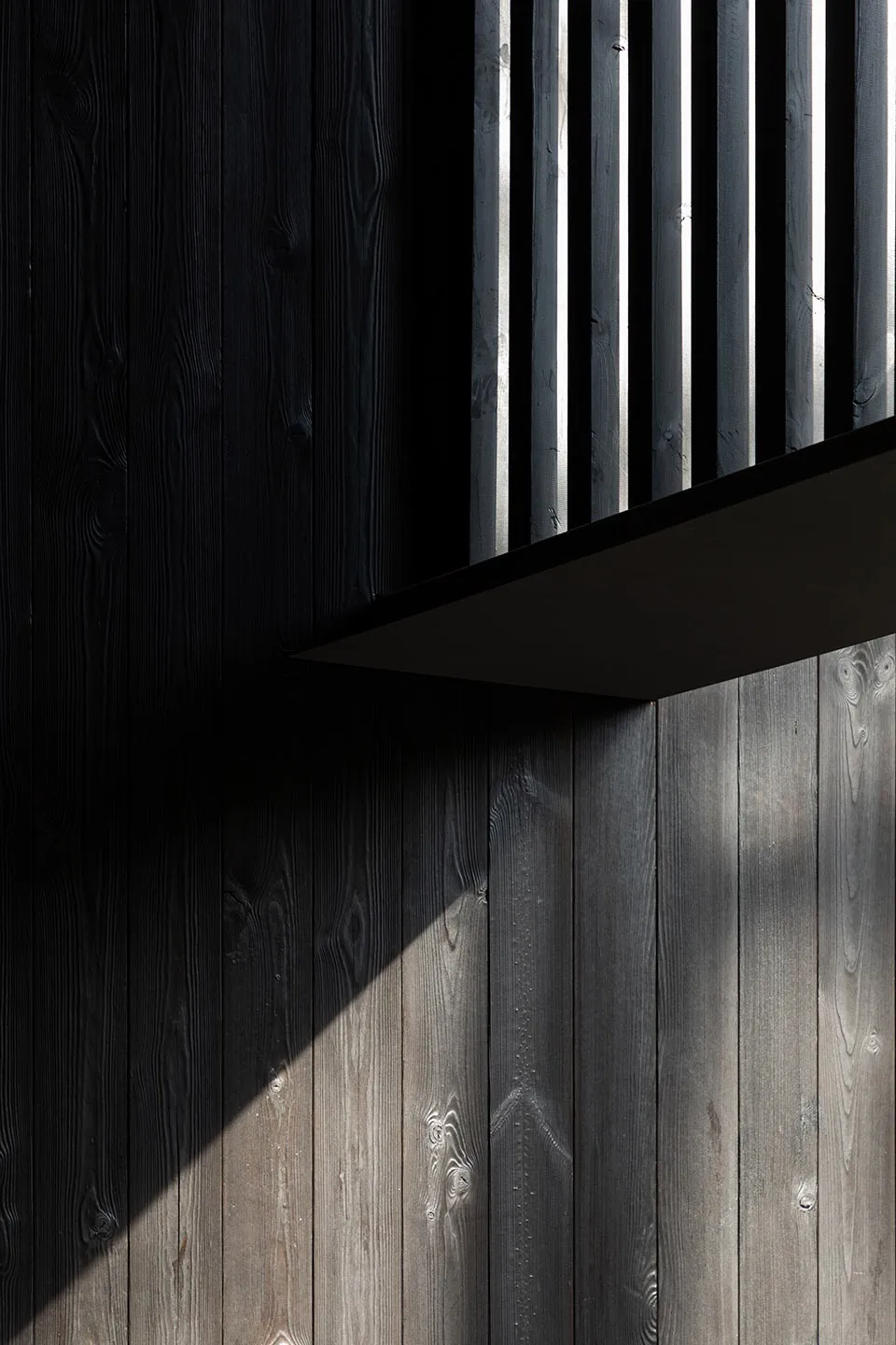 A modern interior design featuring black wooden materials.